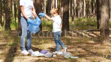 一个小<strong>男孩</strong>在<strong>树林</strong>里收集垃圾，和他的母亲一起放进一个袋子里。 家庭活动家关心大自然